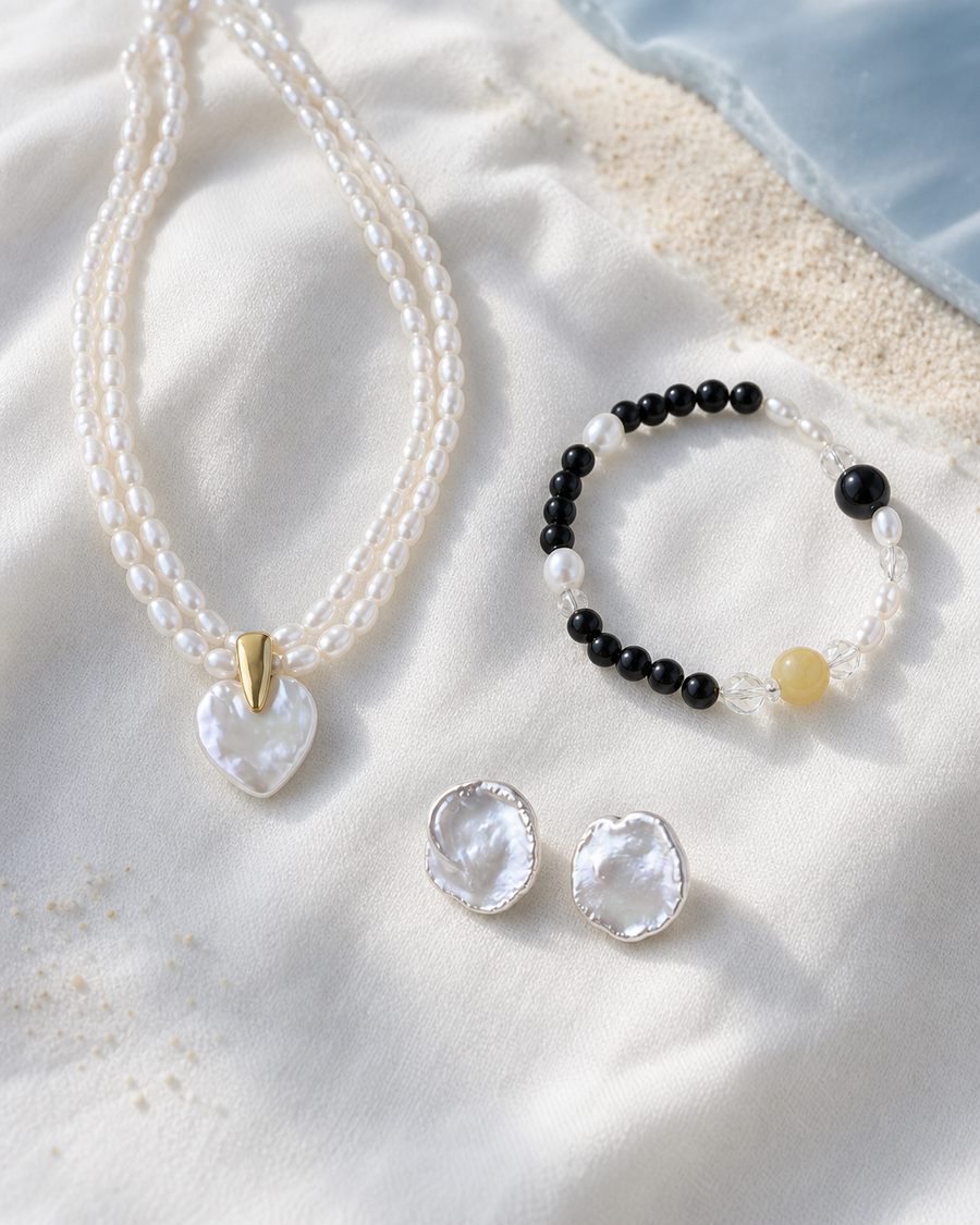MEKAA pearl necklace, bracelet and earrings laid on white linen